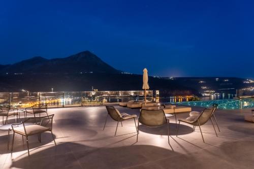 a patio with chairs and a pool at night at Manifest Boutique Hotel in Oítilon