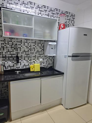una cucina con frigorifero bianco e bancone di Casa de Veraneio em Monte Gordo Guarajuba a Camassari