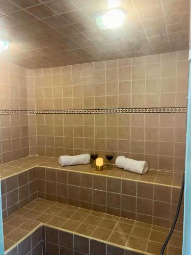 a tiled shower with two towels and a candle at El Ensueño Ecohostal & Glamping in Mocoa