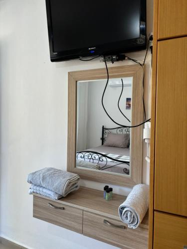 a mirror with a television on top of it at Cheap holiday rooms in Himare