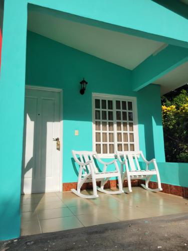 two chairs and a table on the front of a house at Hotel Museo El Ceibo in San José del Sur