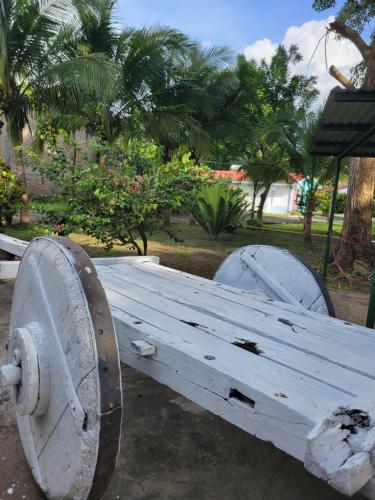 a white wooden bench sitting in a park at Hotel Museo El Ceibo in San José del Sur