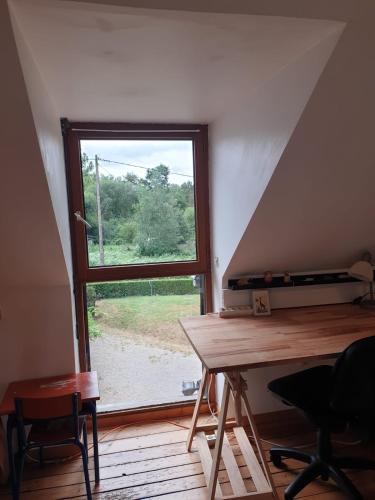 Cette chambre comprend une fenêtre, une table et des chaises. dans l'établissement Longère en Bretagne, à Nouvoitou