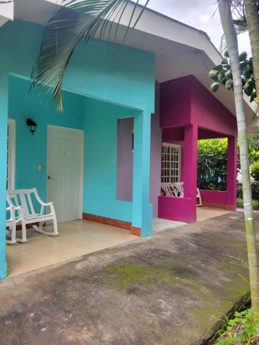 a house with a blue and pink facade at Hotel Museo El Ceibo in San José del Sur