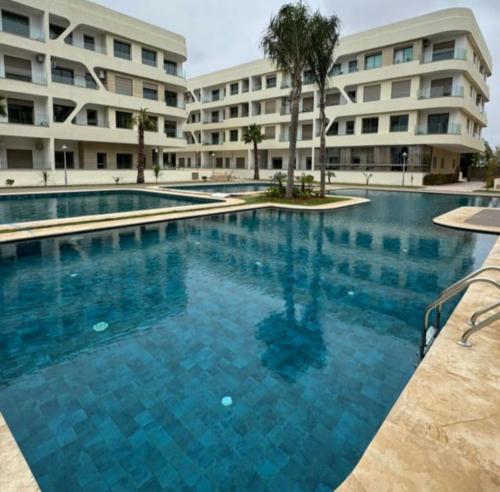 a large swimming pool in front of a building at Appartement à Louer GARDEN PARADISE BOUZNIKA in Bouznika