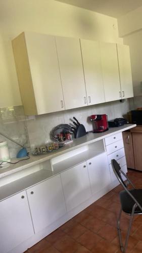 a kitchen with white cabinets and a table and a chair at Dom "Honorat", Kamianna 70, 33-336 in Kamianna