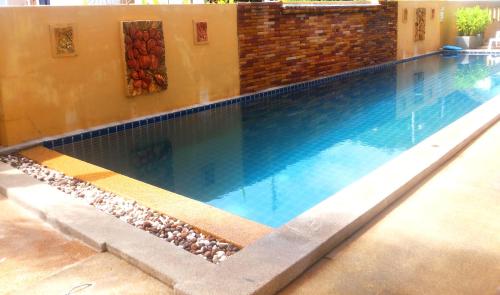 a swimming pool with blue water in a building at Hathai House in Lamai