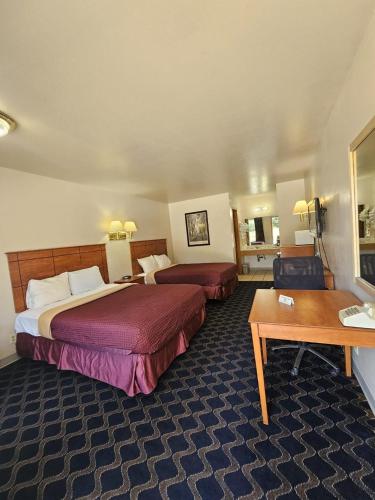 a hotel room with two beds and a table at Boomtown Inn in Drumright