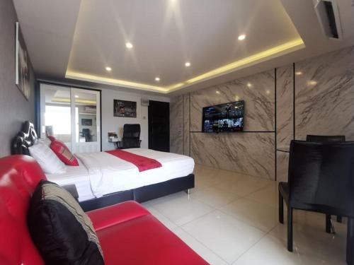 a bedroom with a large bed and a red couch at Luxury beach studio 9 floor in Pattaya