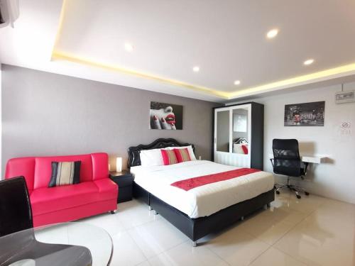 a bedroom with a bed and a red couch at Luxury beach studio 9 floor in Pattaya
