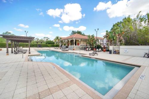 a swimming pool in a yard with a house at Vibrant 4BR Family Townhome 1 mile from Disney World and Disney Springs in Orlando