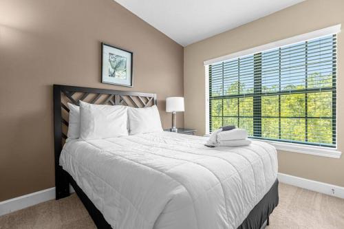 a bedroom with a large bed and a large window at Vibrant 4BR Family Townhome 1 mile from Disney World and Disney Springs in Orlando
