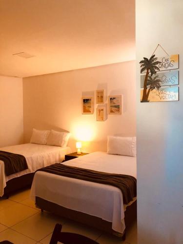 a hotel room with two beds in a room at Águas da Barra in Maragogi