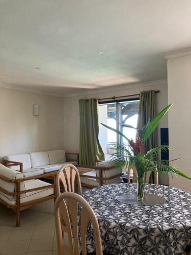 a living room with a table and a couch at Sunset Boulevard, Grand Baie in Grand Baie
