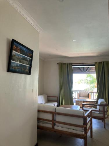 a living room with a couch and a tv on the wall at Sunset Boulevard, Grand Baie in Grand Baie