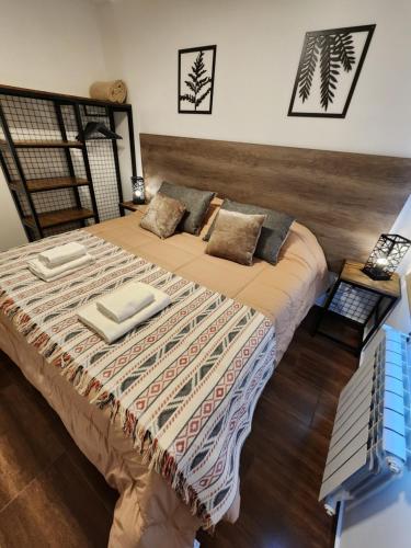 a bedroom with a bed with two towels on it at COMARCA SUR Apartamentos in Ushuaia