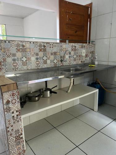 a kitchen with a counter with pots and pans at Lar sossego in Itabuna