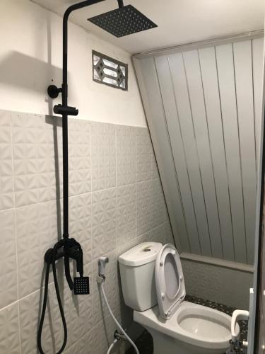 a small bathroom with a toilet and a shower at Rinjani Eger Bungalow in Sembalun Lawang