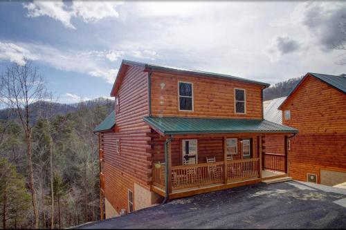 a log cabin with a porch and a deck at NEWLY Built! 5BR-5BH-Hottub-WIFI-Theater-Pool Tble in Pigeon Forge