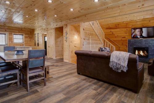 a living room with a couch and a fireplace at NEWLY Built! 5BR-5BH-Hottub-WIFI-Theater-Pool Tble in Pigeon Forge