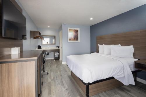 a hotel room with a bed and a desk at Days Inn by Wyndham Arroyo Grande Pismo Beach in Arroyo Grande
