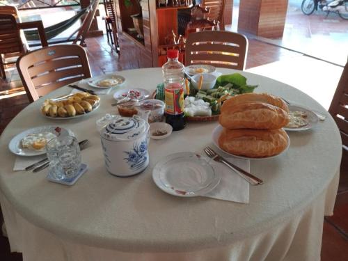 a white table with plates of food on it at CAN THO ECO Home - My Thuan Homestay in Can Tho