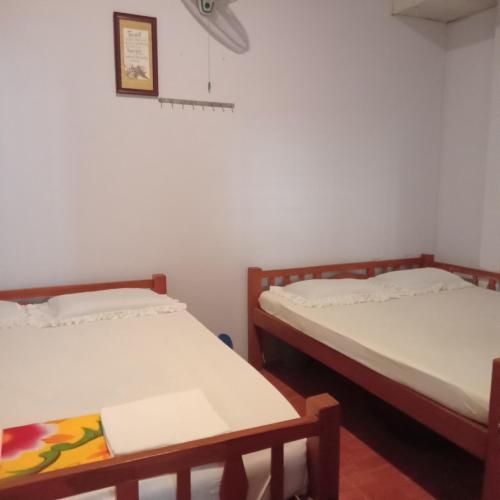 two twin beds in a room with a picture on the wall at CAN THO ECO Home - My Thuan Homestay in Can Tho