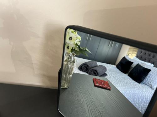 a vase of flowers on a table next to a bed at Cathedral Court in Brumby