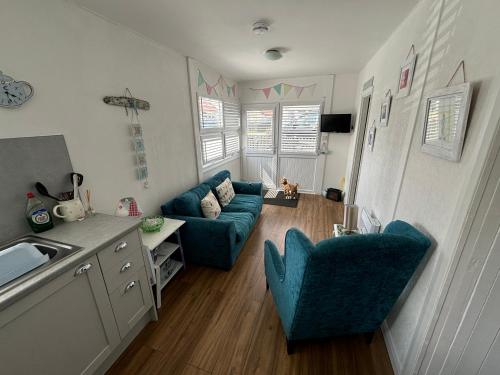 a living room with two blue chairs and a couch at 33B South Shore Village in Bridlington