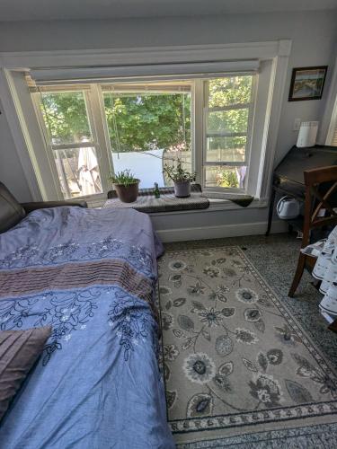 a bedroom with a bed and a window with potted plants at Large Suite w/ Private Bath,great location in Boston
