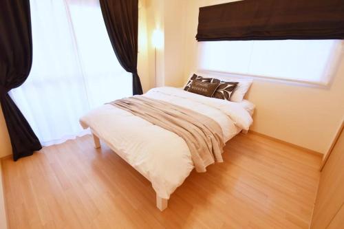 una camera da letto con un letto con due cuscini sopra di カモミール西町 203 a Kume
