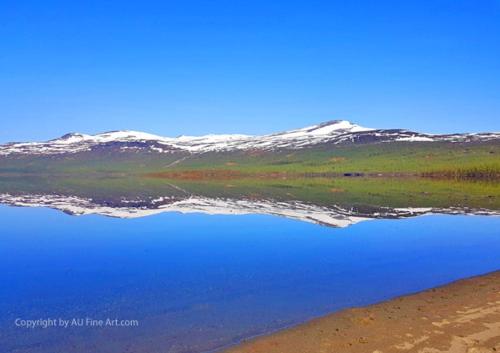 a body of water with snow capped mountains in the background at Eternus Paradise in Tärnaby