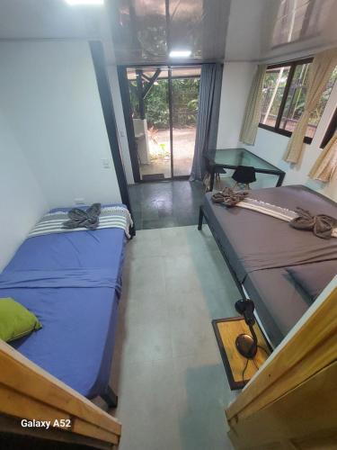 a room with two beds and a table in it at Jungle AC Suite for 3-Kitchen-Walk to Playa Chiquita -Villa Toronto in Cocles