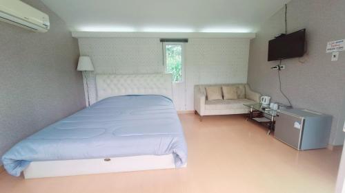a bedroom with a large bed and a couch at C-HILL@KHAOKHO in Khao Kho