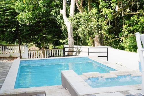 a swimming pool with two chairs next to it at Villa Plasencia in Manabao