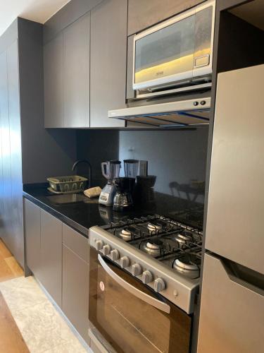 a kitchen with a stove and a microwave at Mexico City loft in the heart of Roma Norte steps away from Cibeles in Mexico City