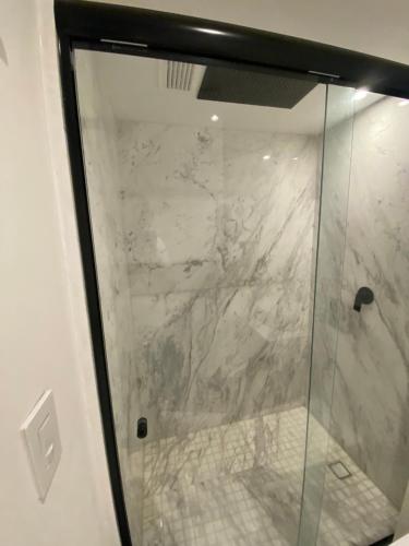 a shower with a glass door in a bathroom at Mexico City loft in the heart of Roma Norte steps away from Cibeles in Mexico City