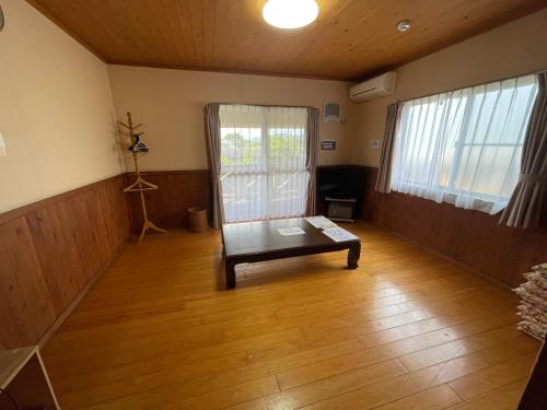 a room with a table in the middle of a room at 源泉かけ流し離れの宿 きなっせ in Yamaga