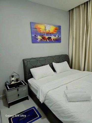 a bedroom with a bed and a night stand next to it at The Shore Home Suites Kota Kinabalu City Sabah Center in Kota Kinabalu