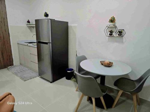 a kitchen with a table and a refrigerator at The Shore Home Suites Kota Kinabalu City Sabah Center in Kota Kinabalu