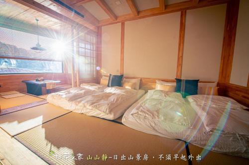 a bedroom with two beds in a room with a window at Alishan Hinoki B&B in Leye