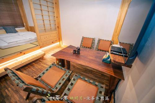 a room with a table and chairs and a bed at Alishan Hinoki B&B in Leye