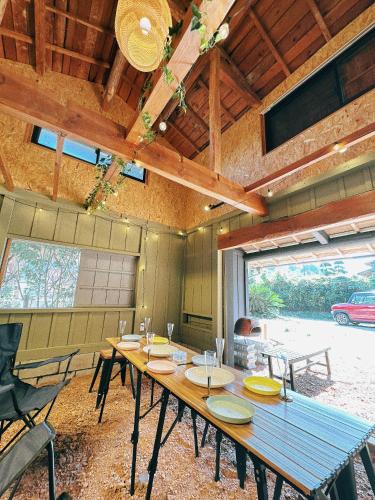 a large wooden table in a room with a large window at 古民家ワーケーション ふふ庵｜駅徒歩5分｜ゆる旅｜屋根在りBBQ施設｜テレワーク in Ōhara