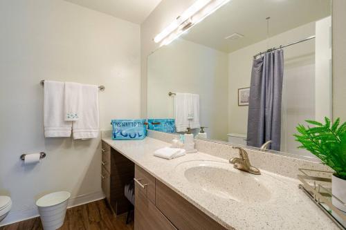 a bathroom with a sink and a large mirror at Cozy Coastal Retreat Newport Beach in Newport Beach