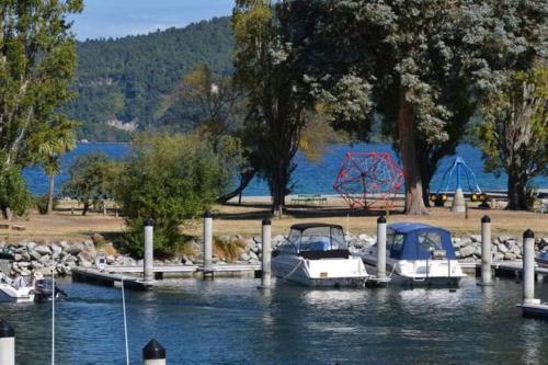 a group of boats docked at a dock on a lake at The Fantail Couples Retreat in Kinloch