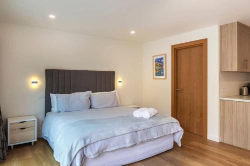 a bedroom with a large bed and a kitchen at The Fantail Couples Retreat in Kinloch