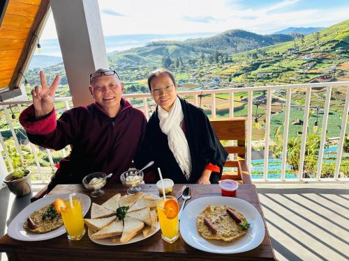 two people sitting at a table with a plate of food at Cabin 7000 feet Nuwaraeliya in Nuwara Eliya