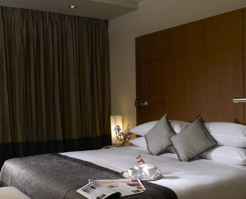 a hotel room with a large bed with a book on it at Radisson Blu Dhaka Water Garden in Dhaka