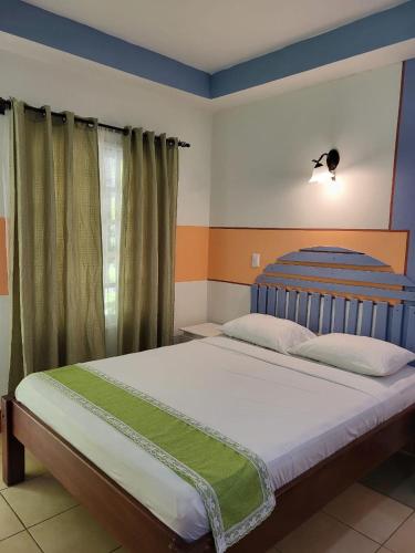 a bedroom with a large bed with a blue headboard at Hotel Museo El Ceibo in San José del Sur