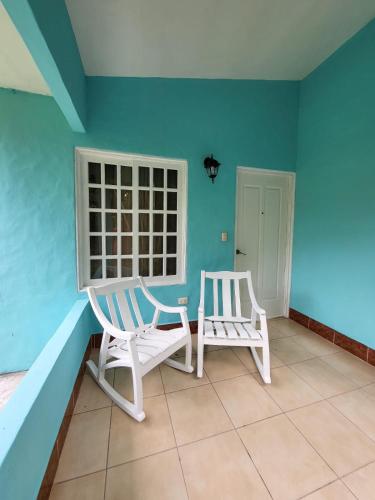 two chairs in a room with a blue wall at Hotel Museo El Ceibo in San José del Sur